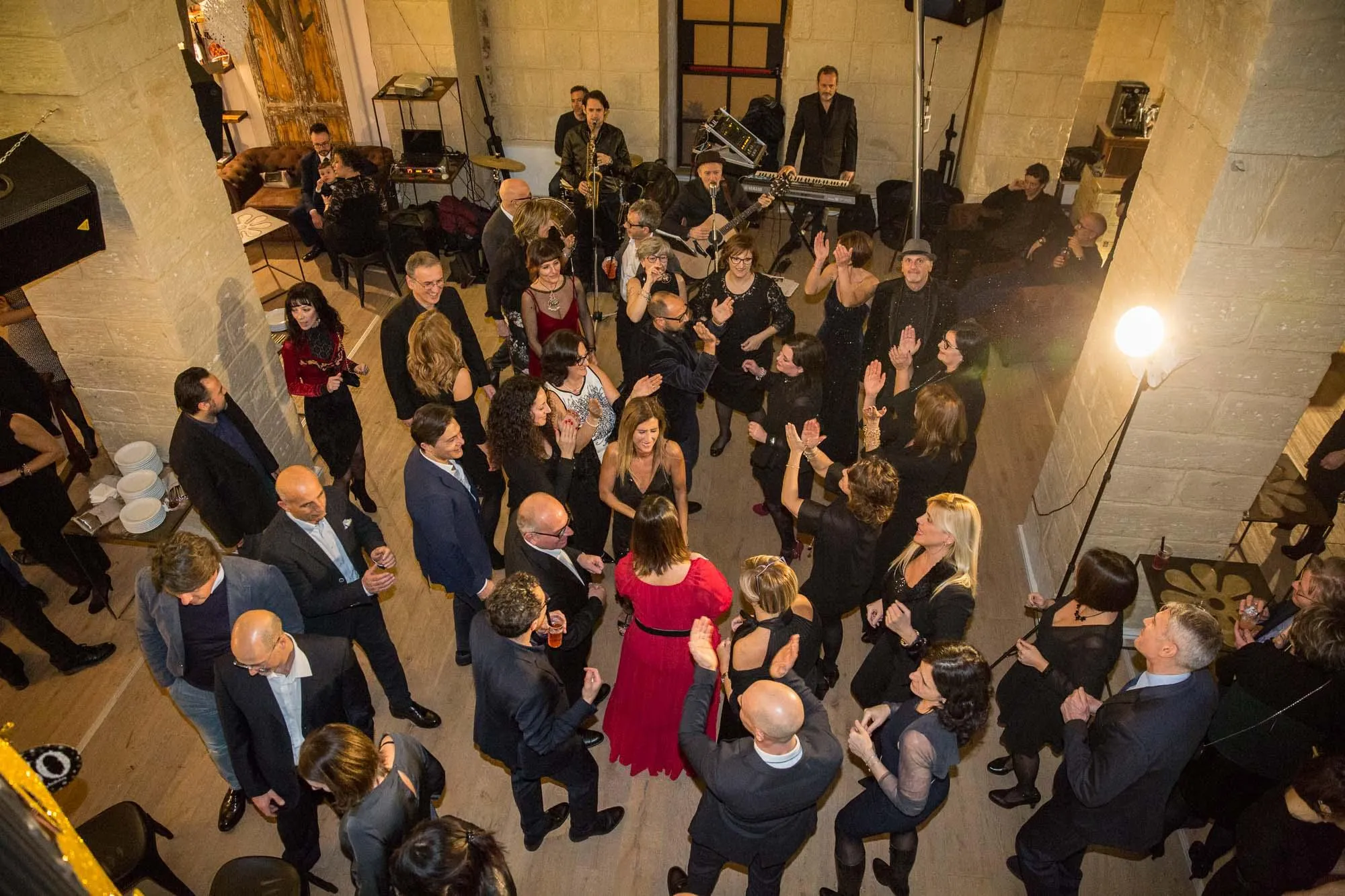 Una festa a Palazzo Mandurino vista dall’alto: gli ospiti in abito da sera fra le volte in pietra, e i musicisti sul fondo.